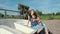 Mother and son are sitting on a boat on a wooden pier and enjoying the countryside.