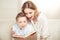 Mother and son sitting embracing and reading book together