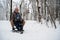 Mother and son sledding in the winter forest