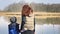 Mother and son are standing on pier at beautiful pond