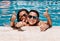 Mother and son with sunglasses are leaning on the edge of the pool on a sunny summer day