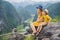 Mother and son tourists on the lake Tam Coc and pagoda of Hang Mua temple, Ninh Binh, Viet nam. It& x27;s is UNESCO World