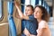 Mother and son in train`s corridor looks in window