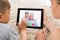 Mother And Son Videoconferencing On Digital Tablet