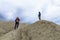 Mother and son visiting muddy volcano. Family climbing dry arid