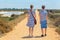 Mother and son walking on sandy path in coastal area