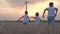 Mother and son walking in wheat field with wind turbines