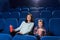Mother and son watching movie in cinema.