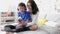 Mother and son wearing headphones using smartphone for singing a song together at home