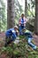 Mother with sons examine moss in pine forest