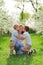 mother with sons kiss and cuddle in flowering garden. mother's day