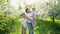 mother with sons walks in flowering garden. youngest child in her arms