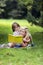 Mother and Special Kid Reading on a Rug Outdoors