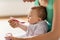 Mother with spoon feeding little baby at home