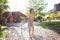 Mother sprays a child with a hose in the courtyard of the house, Boy drenched in water on a hot sunny day