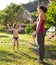 Mother sprays a child with a hose in the courtyard of the house, Boy drenched in water on a hot sunny day