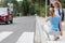 Mother squats on the sidewalk and explains to the little boy how to cross the street safely