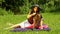 Mother in straw hat combing daughter in the park