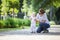 Mother supporting baby daughter and helping her make first steps