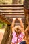 Mother Supporting daughter in the playground with climbing and hanging on a ladder