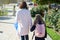 Mother taking child to school. Holding hands, background - autumn city.