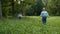 Mother taking a pictures using retro film camera of her baby boy in a summer park