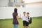 Mother taking sons to school together, hand wave say goodbye