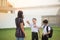 Mother taking sons to school together, hand wave say goodbye