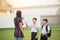 Mother taking sons to school together, hand wave say goodbye