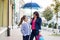 Mother talks with her daughter for ten years on her way to school. Against the background of the city under an umbrella