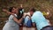 Mother talks to a daughter and kisses her while dad plays with son at the picnic