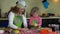 Mother teaches little daughter to knead biscuit dough on kitchen table. 4K