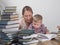 Mother teaches son to read among the stacks of books