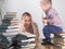 Mother teaches son to read among the stacks of books