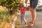 Mother teaching baby daughter first steps outside in the sunset