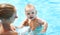 Mother teaching baby swimming pool