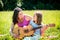 Mother teaching daughter playing guitar