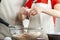 A mother is teaching her little daughter how to cook.