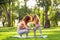 Mother teaching her small daughter yoga in the park at daytime