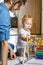 Mother teaching little kid counting on multi colored childish wooden ecological abacus on floor