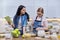 Mother and teenage daughter cooking at home in the kitchen.