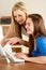 Mother And Teenage Daughter At Home Using Computer