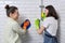 Mother and teenager daughter cleaning together in bathroom