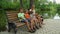 Mother with three kids sitting on the bench and eating apples