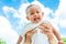 Mother throw up baby daughter with towel on blue sky background