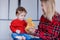 Mother and toddler baby play with teddy bead at home