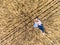 Mother and toddler daughter lying back on dry wheat field, top view from drone, woman embracing her little child