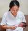 Mother training feeding milk infant baby by glass cup