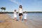 Mother and two chil son and daughter walking on the beach