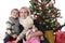 Mother with two children lookig up under Christmas tree